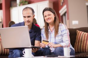 Latin descent couple paying monthly bills at home.