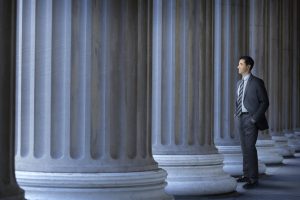 Lawyer Or Banker Standing Next To Large Columns